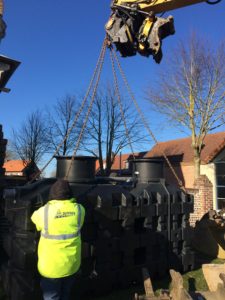 Levage de la micro station d’épuration FLUIDIFIX® au-dessus du mur par une pelle de 12 tonnes